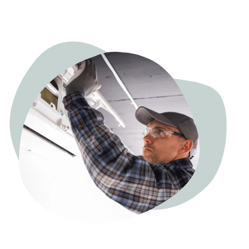 Image of an HVAC technician working on a unit.